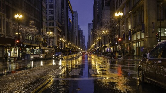 Image cars on road between high rise buildings during night time