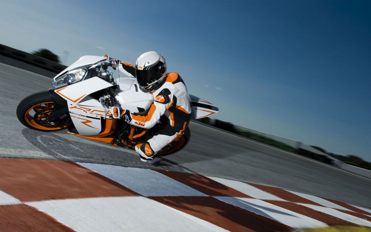 white and orange sports bike on track field