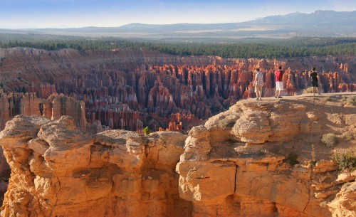 Image people standing on brown rock formation during daytime