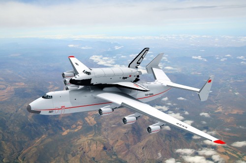 Image white and red airplane on top of brown mountain during daytime