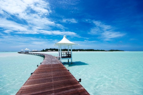 Image brown wooden dock on body of water under blue sky during daytime