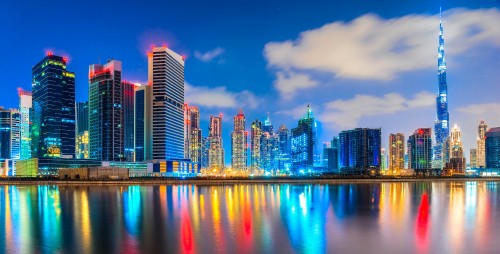 Image city skyline across body of water during night time