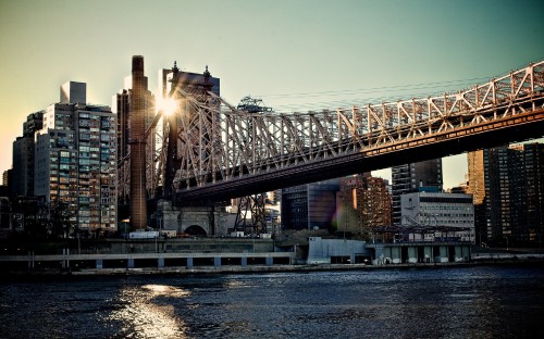 Image bridge over river near city buildings during night time