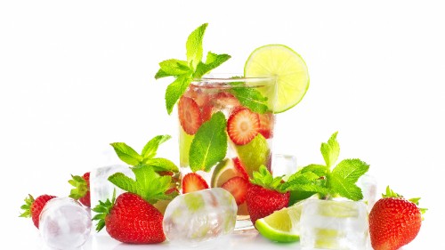 Image sliced strawberries and green leaves in clear glass jar