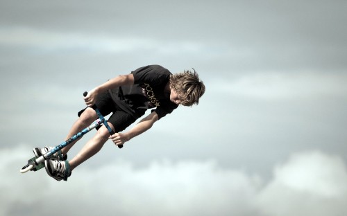 Image man in black t-shirt and blue denim jeans doing hand stand during daytime