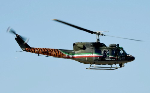 Image green and red helicopter flying during daytime