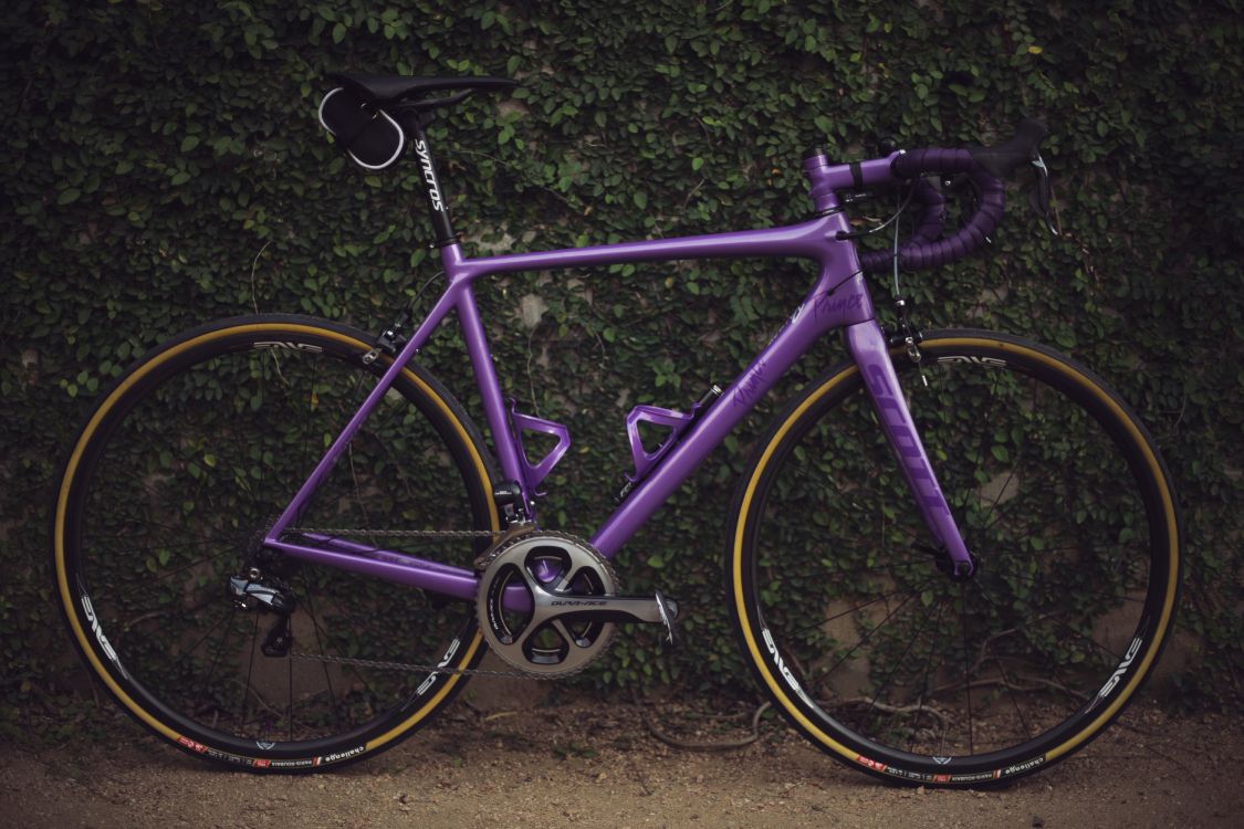 purple road bike on brown dirt