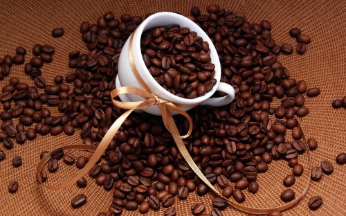 Image brown coffee beans on white ceramic mug