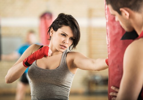 Image woman in gray tank top wearing red gloves