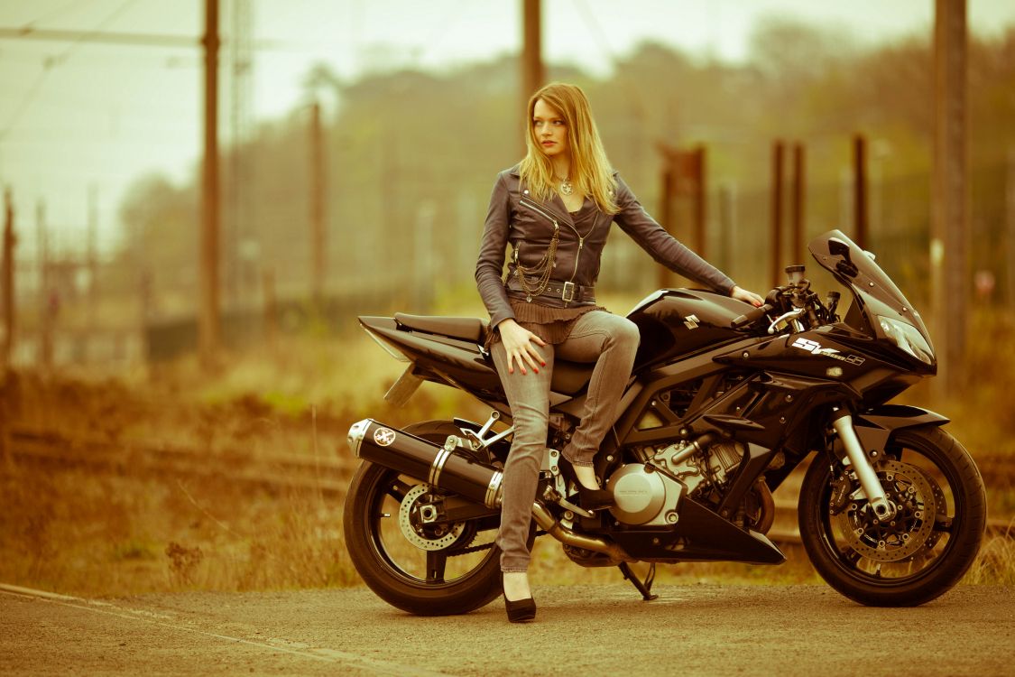 woman in gray jacket and gray pants riding black cruiser motorcycle