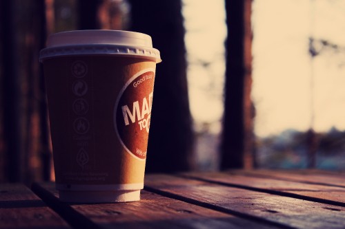 Image brown and white disposable cup on brown wooden table