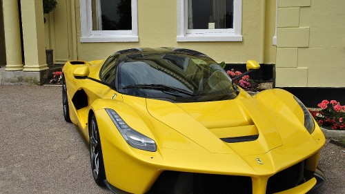 Image yellow ferrari 458 italia parked in front of white house