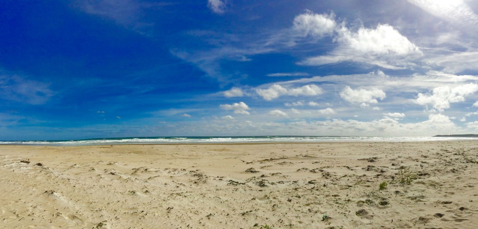 white sand beach under blue sky and white clouds during daytime