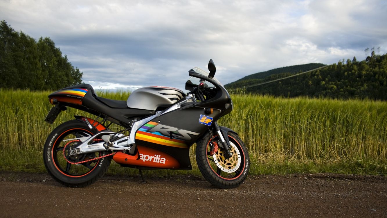 orange and black sports bike on dirt road