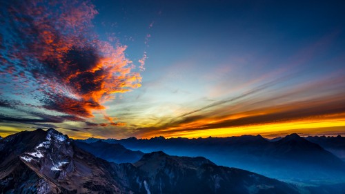 Image snow covered mountain under orange and blue sky