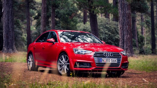 Image red audi a 4 sedan parked on forest during daytime