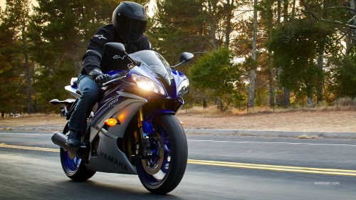 Image man in black jacket riding on white and black sports bike