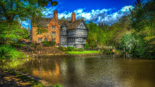 Image brown and gray house beside river under blue sky during daytime