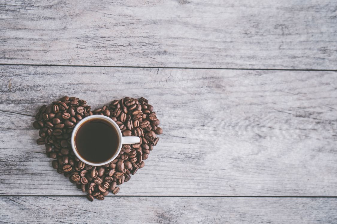 white ceramic mug on brown coffee beans