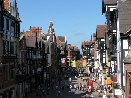 Image people walking on street between buildings during daytime