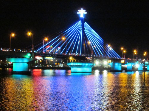 Image blue and white boat on water near bridge during night time