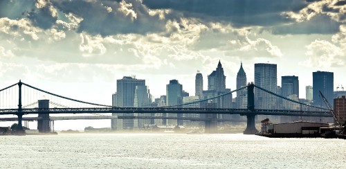 Image bridge over water near city buildings during daytime