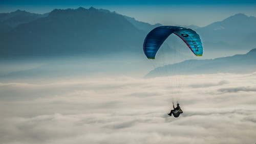 Image person riding parachute over mountain range