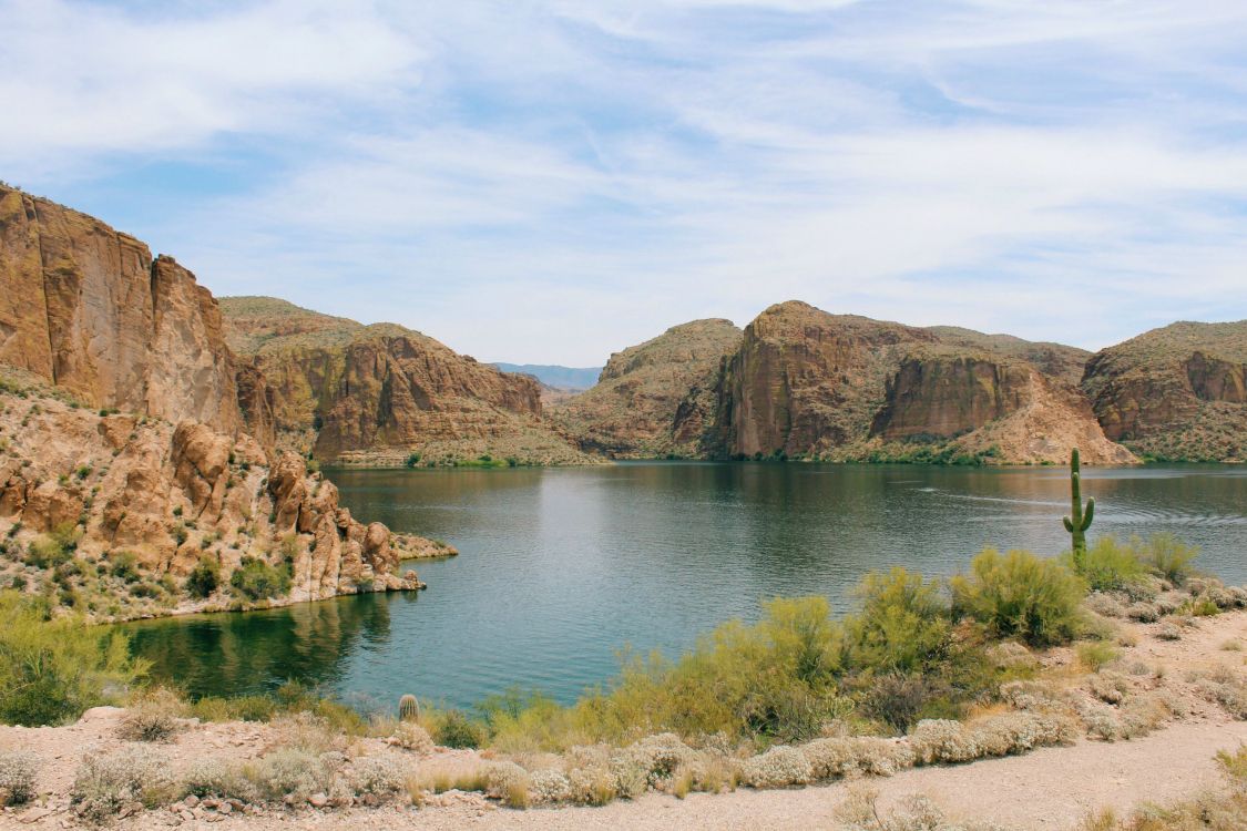 Brauner Felsiger Berg Neben Blauem Meer Unter Blauem Himmel Tagsüber. Wallpaper in 2592x1728 Resolution