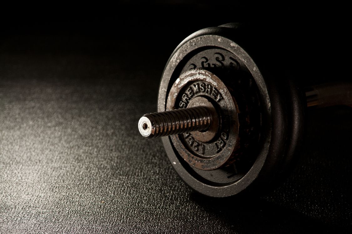 silver and black dumbbell on black textile