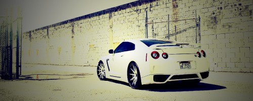 Image white porsche 911 parked beside white brick wall