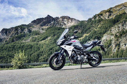 Image white and black sports bike parked on green grass field near green mountains during daytime