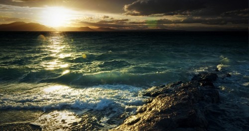 Image ocean waves crashing on shore during sunset