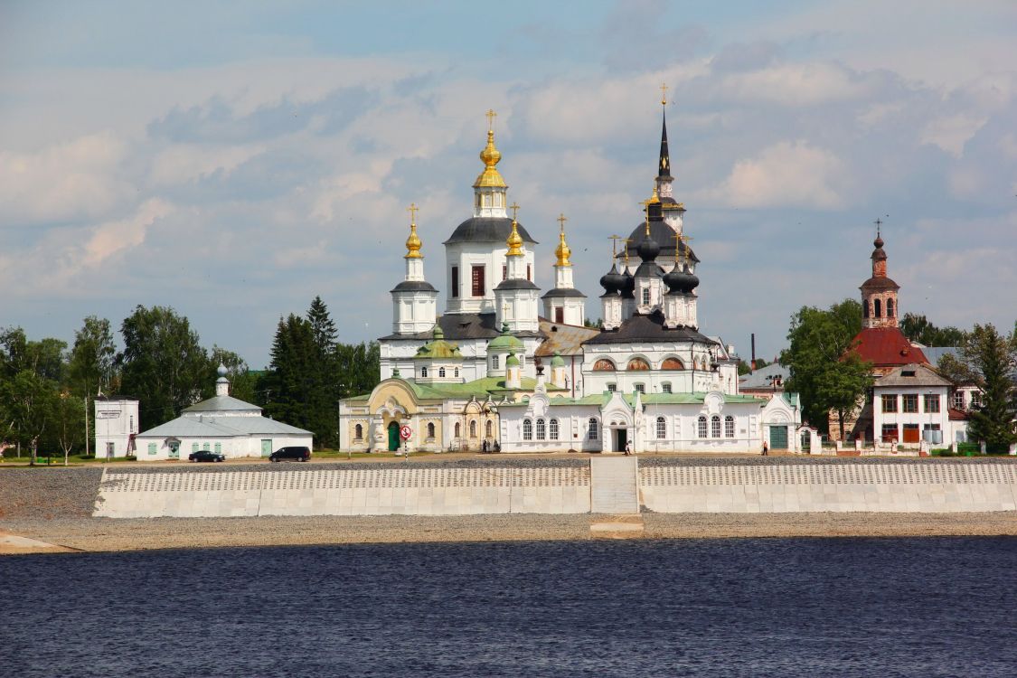 white and gold concrete building near green trees under white clouds during daytime