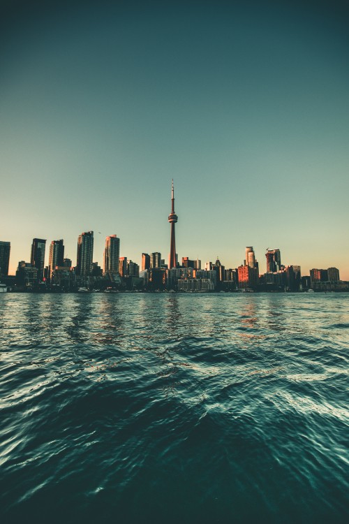 Image city skyline across body of water during daytime