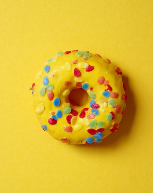 Image doughnut with sprinkles on yellow surface