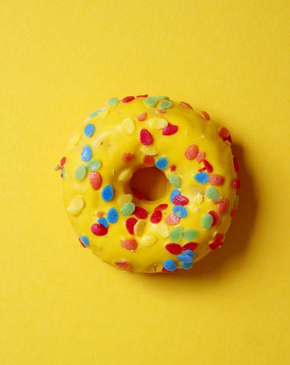 Doughnut With Sprinkles on Yellow Surface. Wallpaper in 5184x6520 Resolution