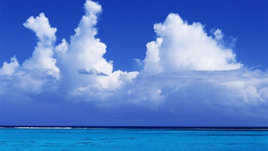 Image blue sea under blue sky and white clouds during daytime