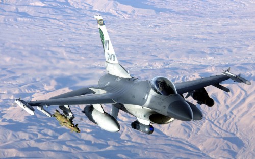 Image gray fighter plane flying over the mountains during daytime