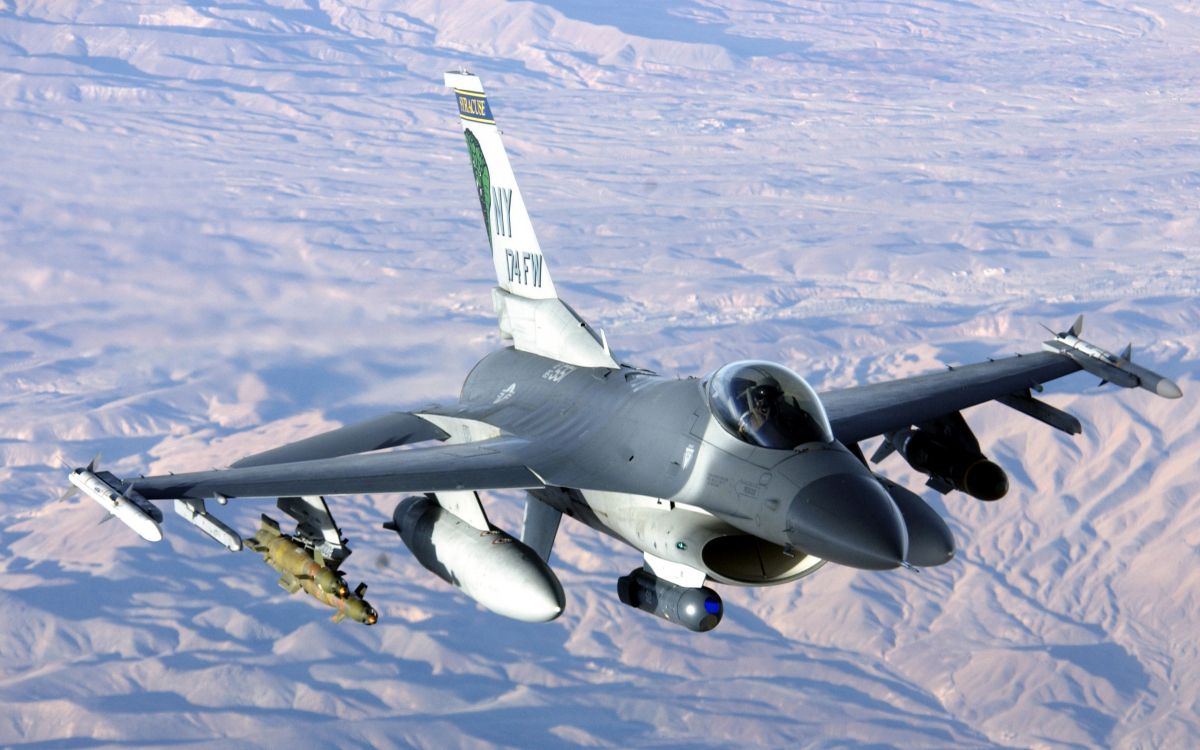 gray fighter plane flying over the mountains during daytime