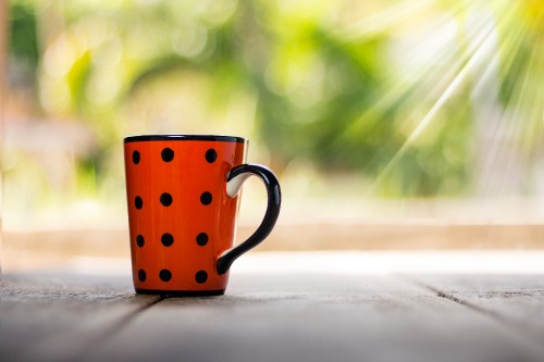 Image red and white polka dot ceramic mug on white table