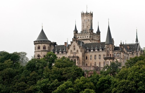 Image brown and gray concrete castle surrounded by green trees during daytime