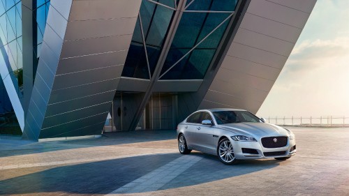 Image silver sedan parked beside white building