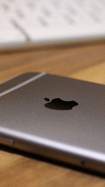 Image silver macbook on brown wooden table