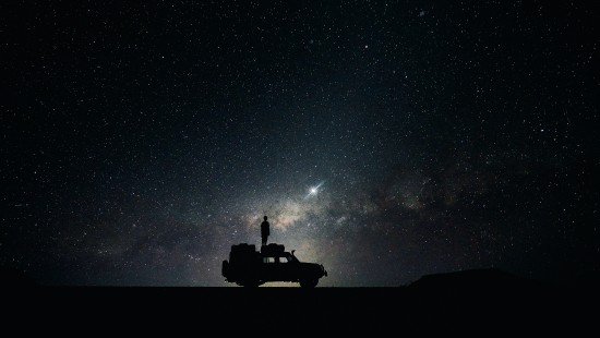 Image silhouette of person riding on yellow car during night time