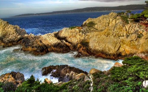 Image brown rocky mountain beside blue sea during daytime