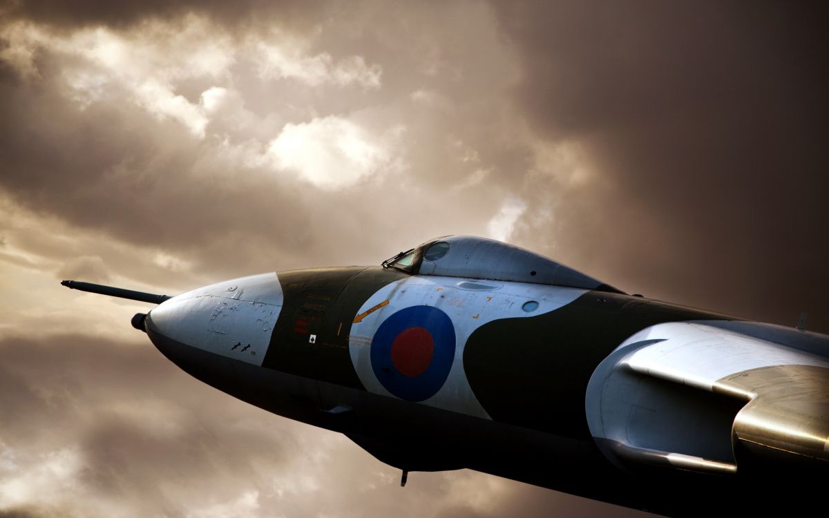 black jet plane under white clouds during daytime