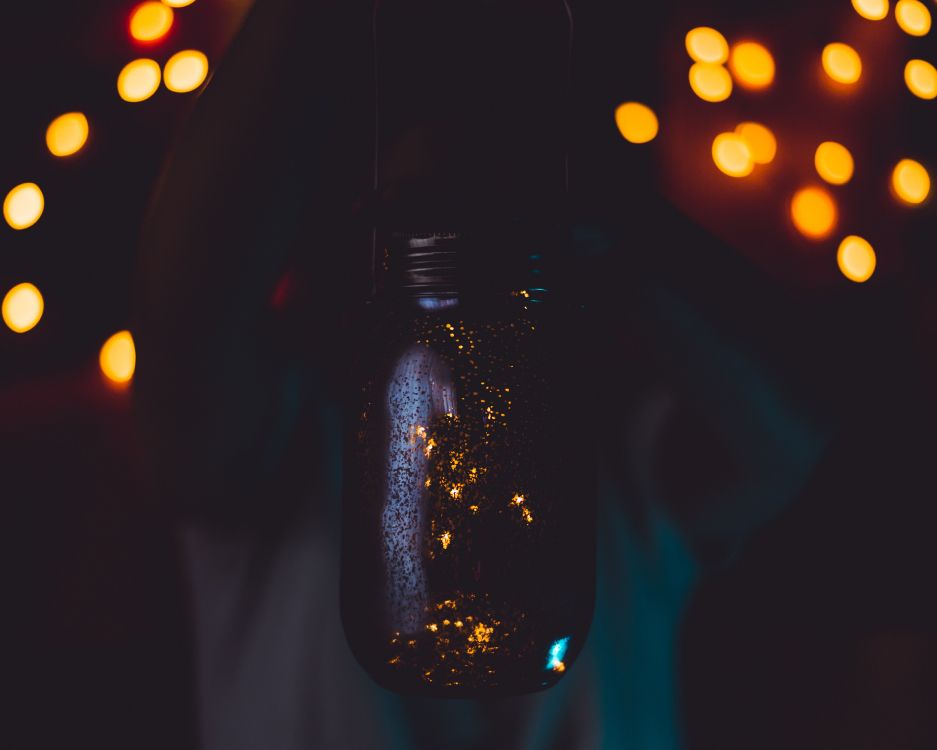 black glass bottle with bokeh lights