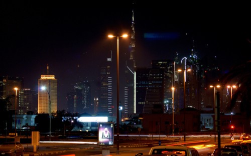 Image cars on road near city buildings during night time