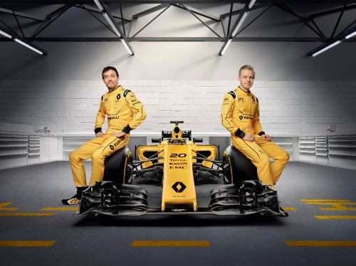 Image 2 men in yellow uniform riding on black and yellow go kart