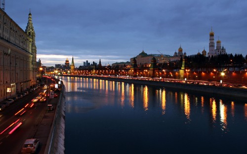 Image city skyline across body of water during night time